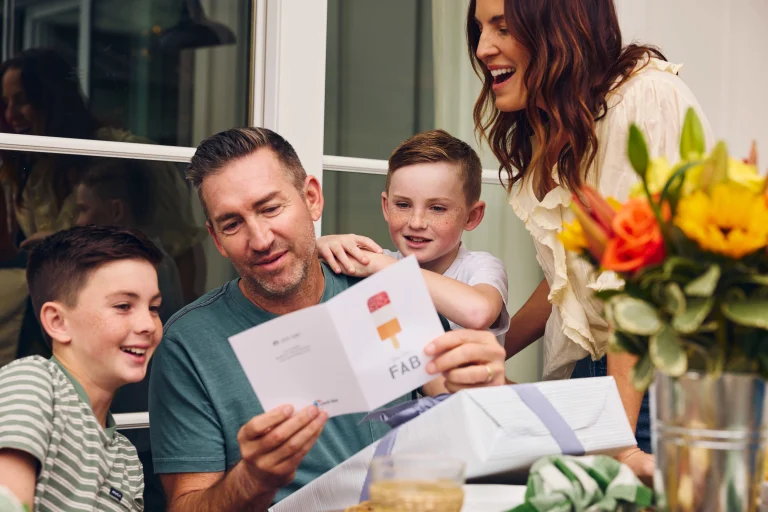 fathers-day-messages-dad-reading-greeting-card-with-kids